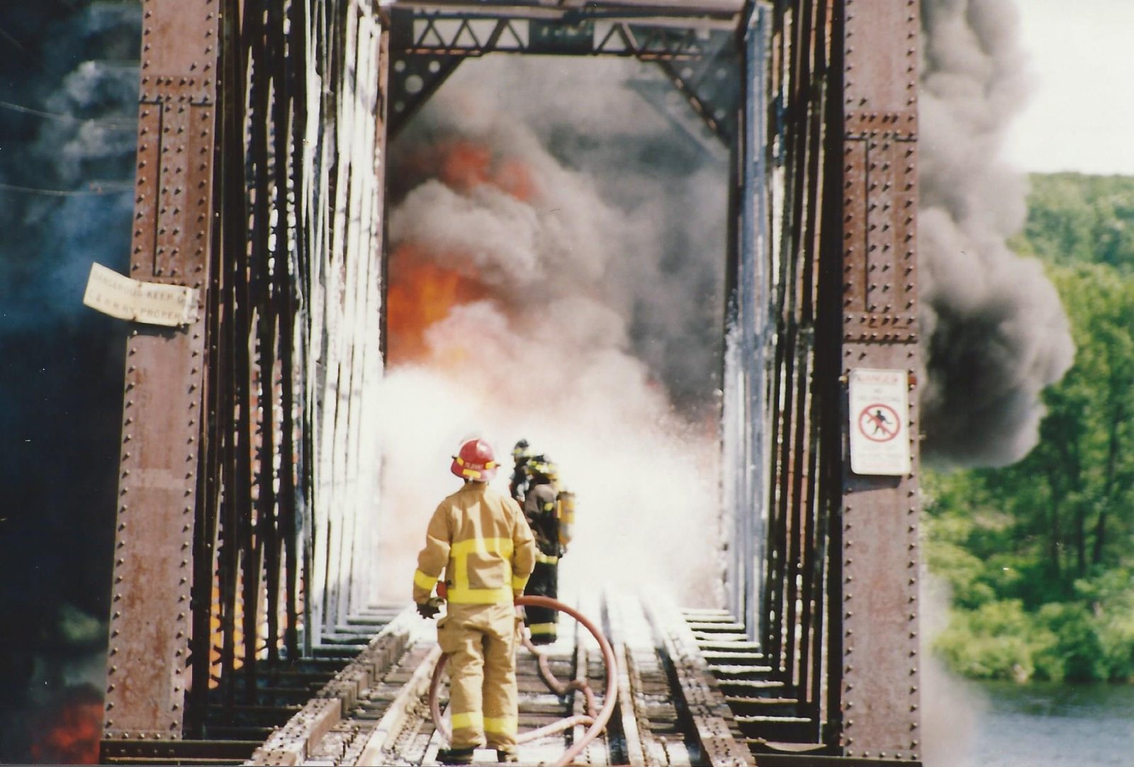 Firefighters battling the burning bridge.  Tom Larson photo